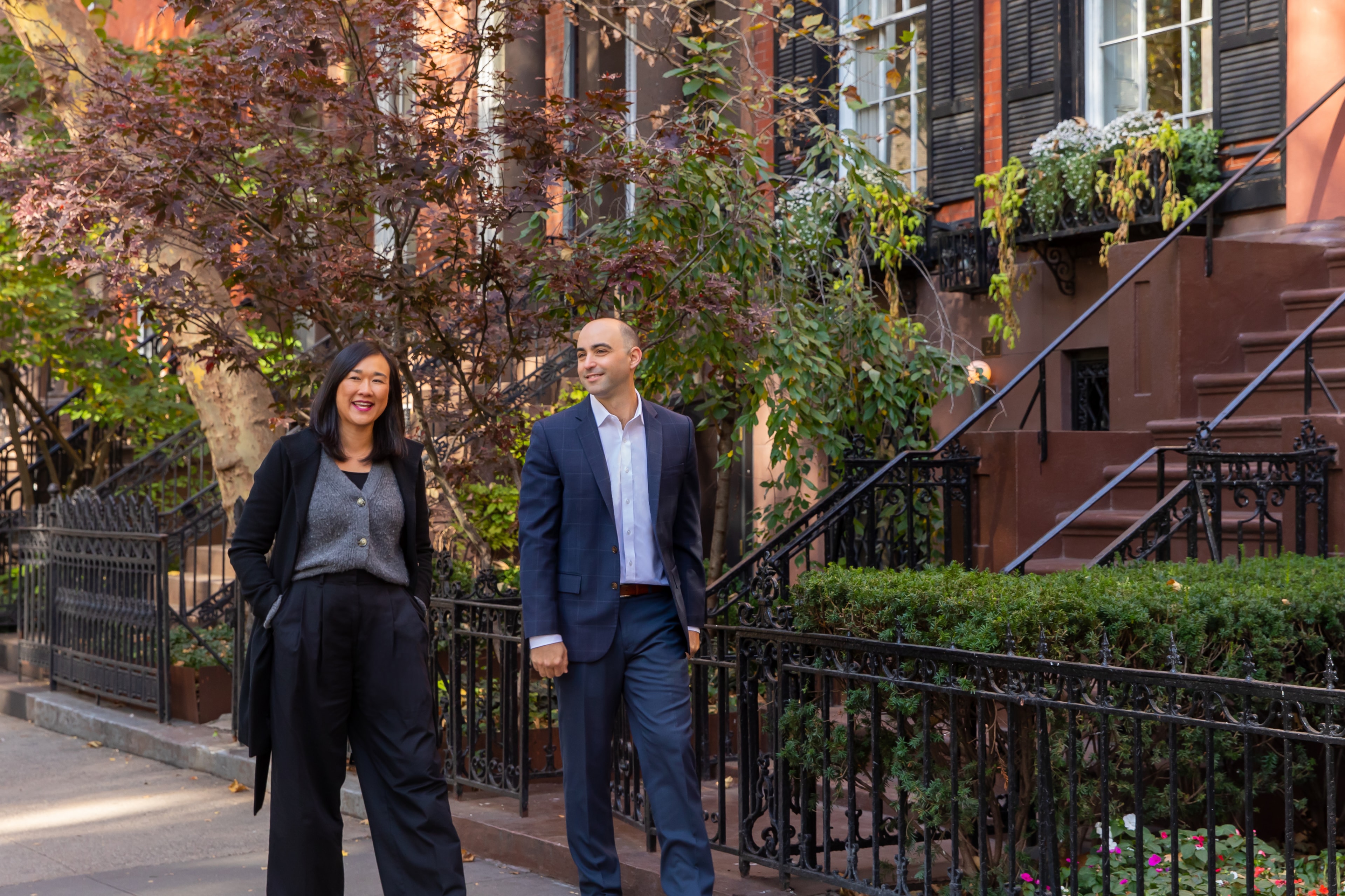 Ian Katz and Wendy Tsang walking a tree-lined brownstone block
