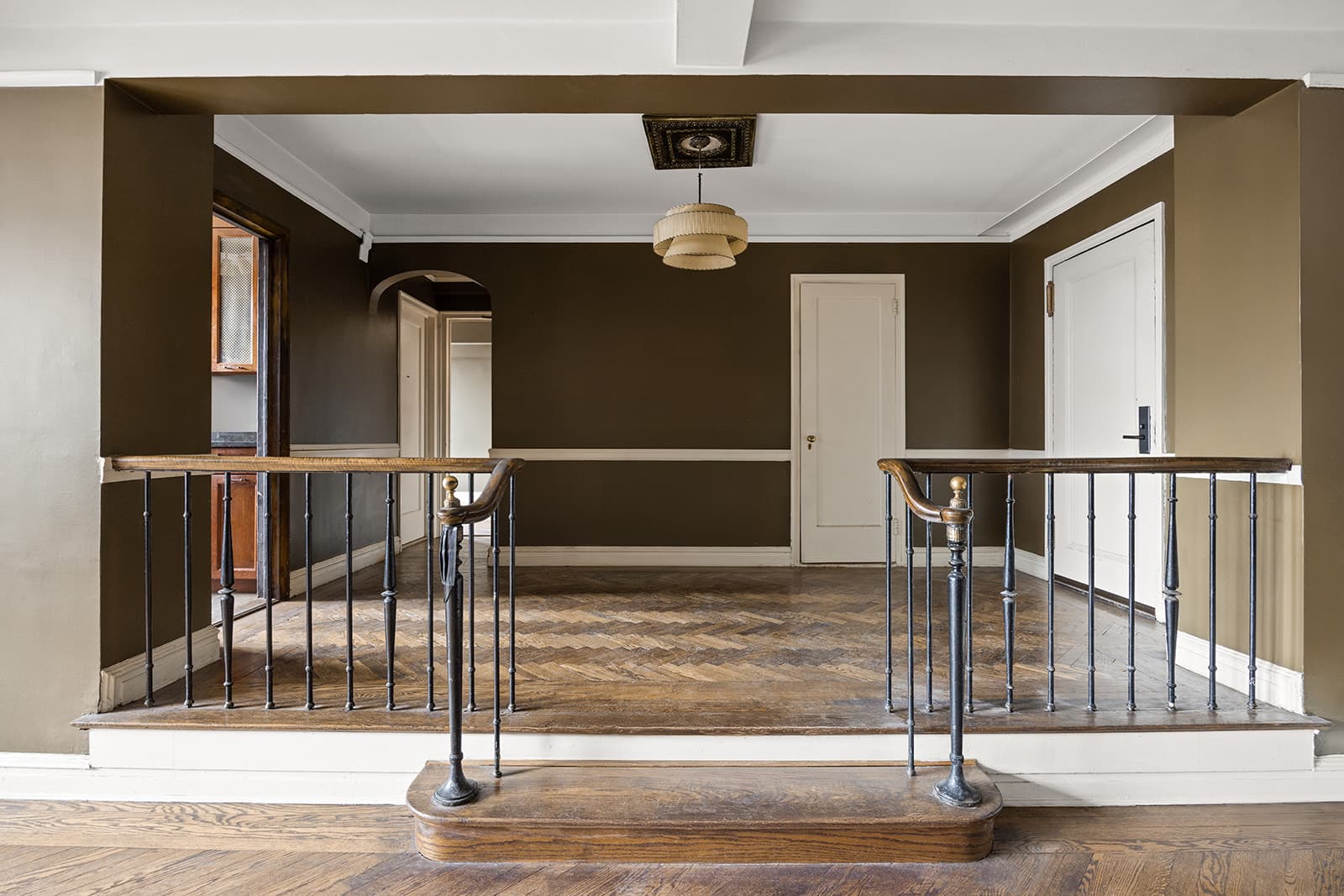 A raised dining landing behind an iron railing