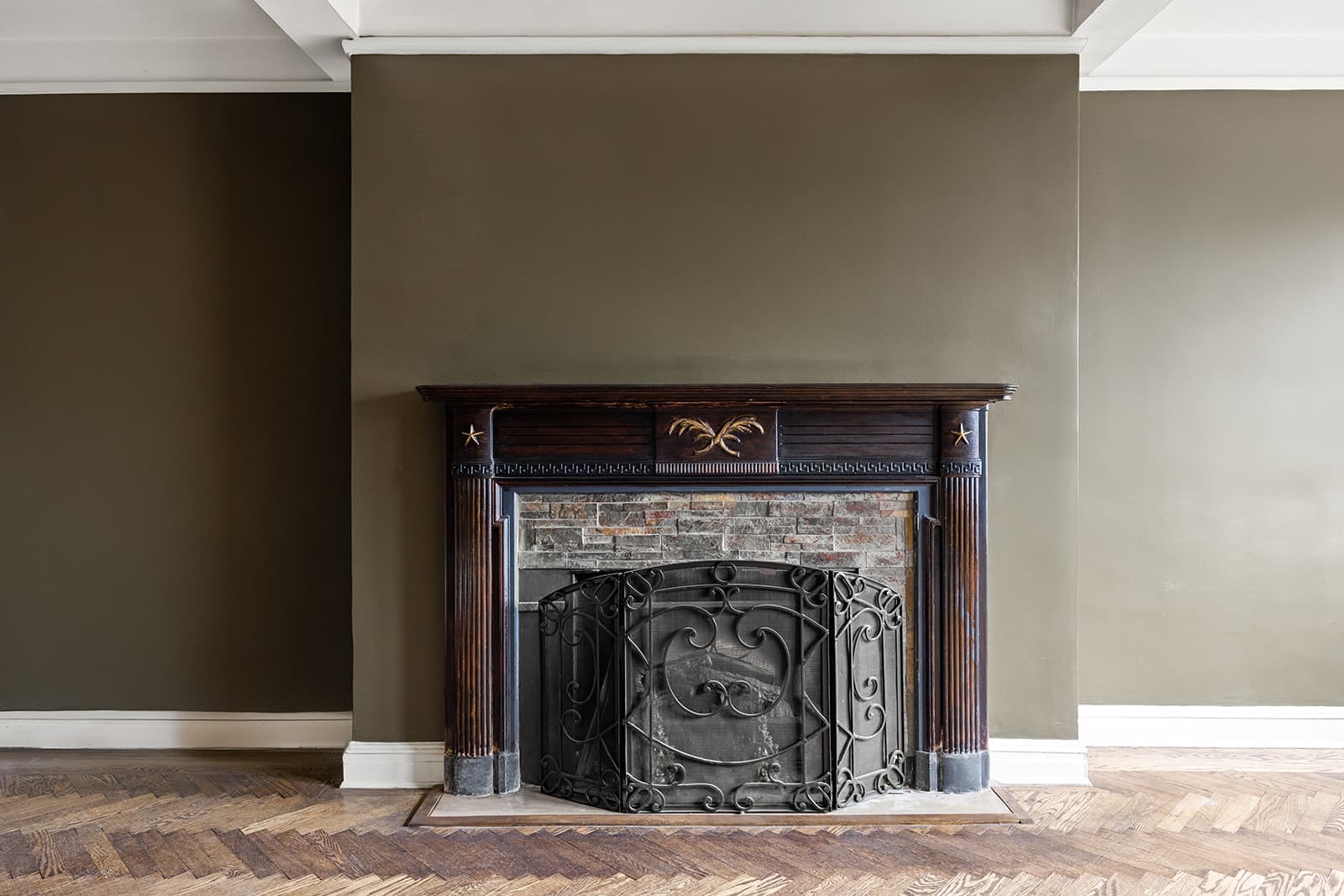 A carved wood fireplace with a stone surround